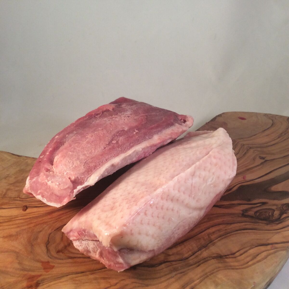 Eendenborstfilets op een houten plank